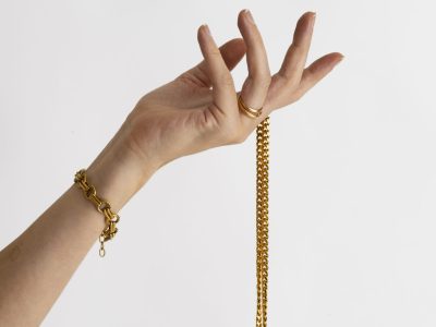 side-view-hand-holding-gold-chain