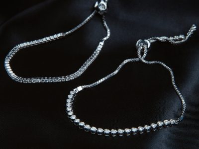 side view of silver bracelets with diamonds on black background